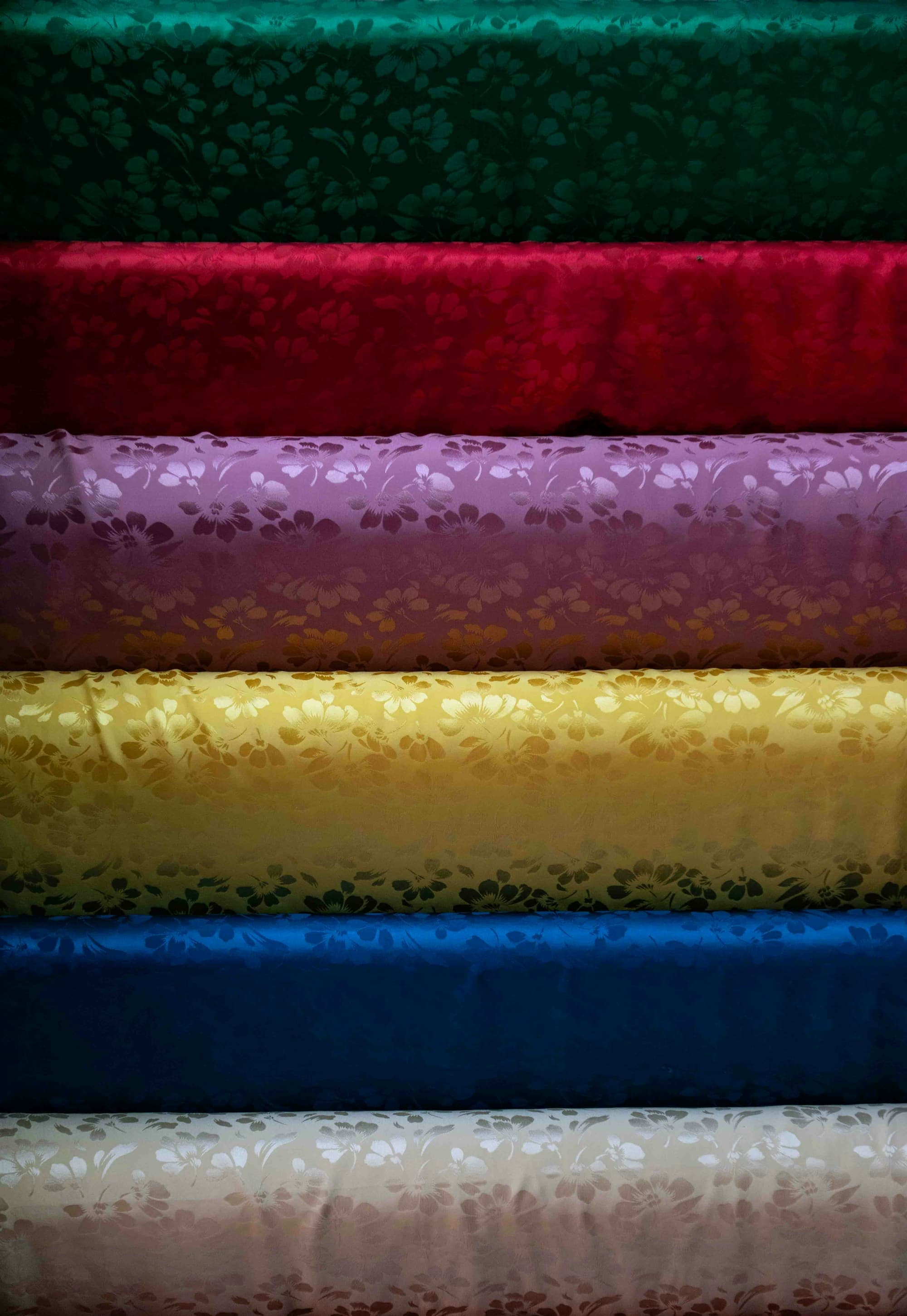 Folded jacquard fabric in six colours stacked on a shelf
