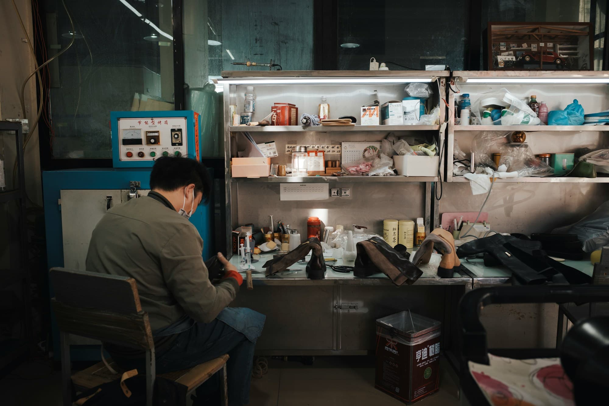 A shoemaker at a workbench in a small footwear factory