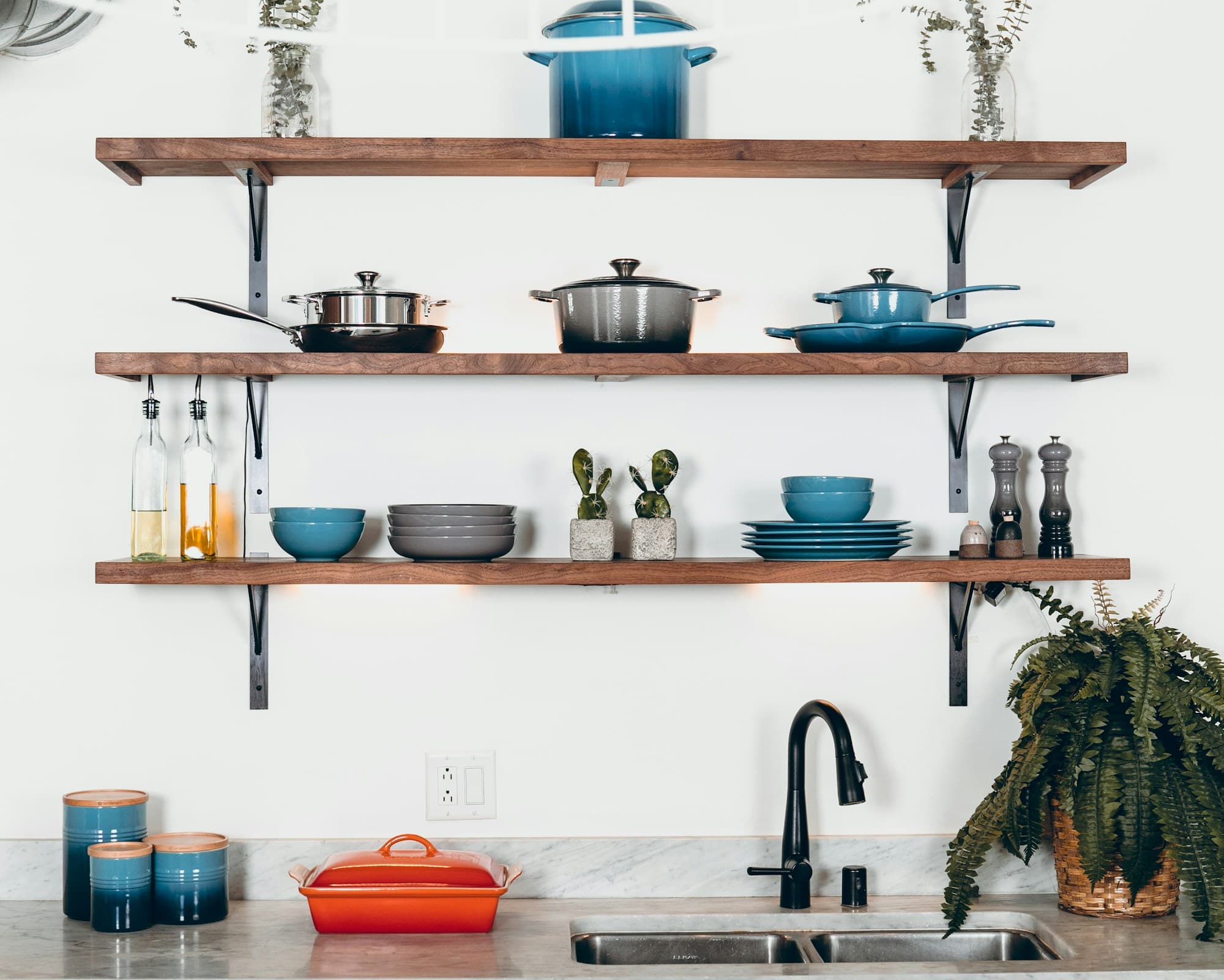 Cookware and bowls arranged on open kitchen shelves